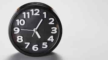 Foto gratuita forma redonda reloj despertador negro sobre fondo gris