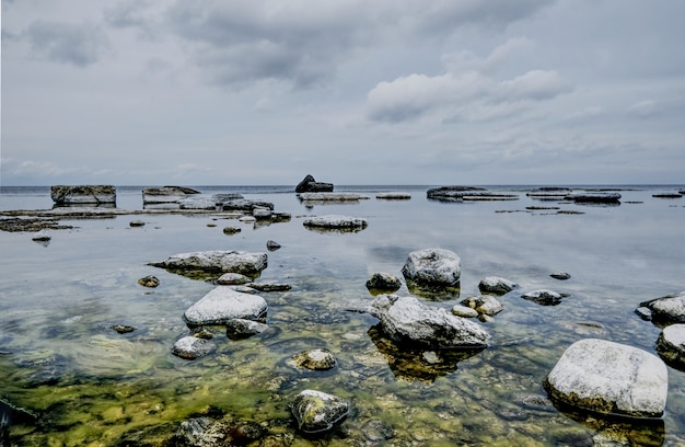 Formaciones rocosas cubiertas de musgo en el lago bajo el cielo nublado