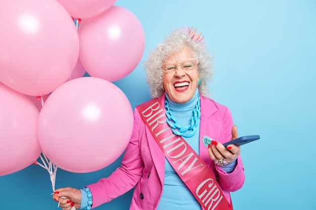 Foto de abuela feliz y positiva que se ríe de algo que se divierte en la fiesta de cumpleaños