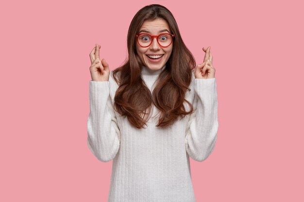 La foto de una adolescente supersticiosa ha emocionado una mirada feliz, cruza los dedos para la buena suerte, cree en algo positivo