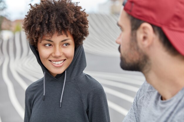 Foto de adolescentes alegres con ropa de moda, de buen humor, que pasen un rato agradable juntos