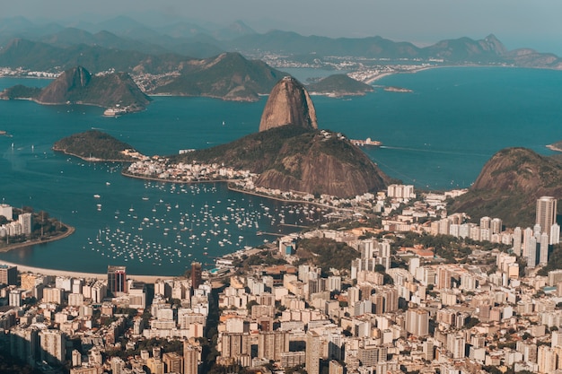 Foto gratuita foto aérea de río de janeiro rodeado por el mar y colinas bajo la luz del sol en brasil