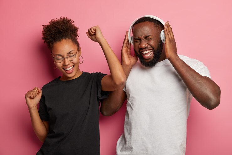 Foto gratuito foto de alegre pareja afroamericana diviértete y baila con música fuerte, celebra la sesión de examen aprobada con éxito, usa auriculares