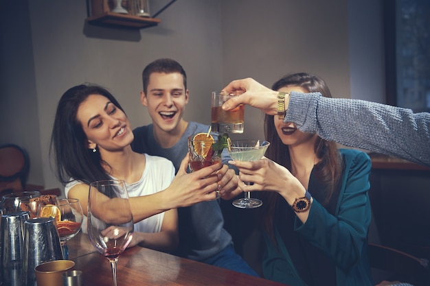 Foto de amigos alegres en el bar o en el pub comunicándose entre ellos