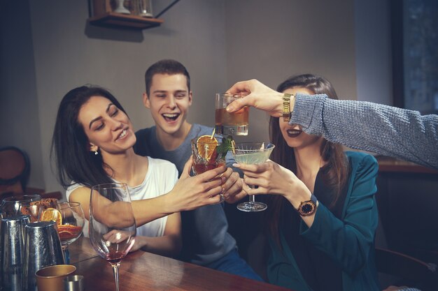 Foto de amigos alegres en el bar o en el pub comunicándose entre ellos