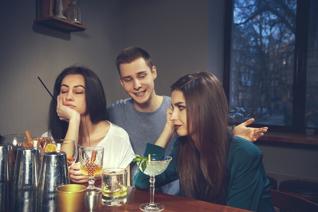 Foto de amigos alegres en el bar o en el pub comunicándose entre ellos