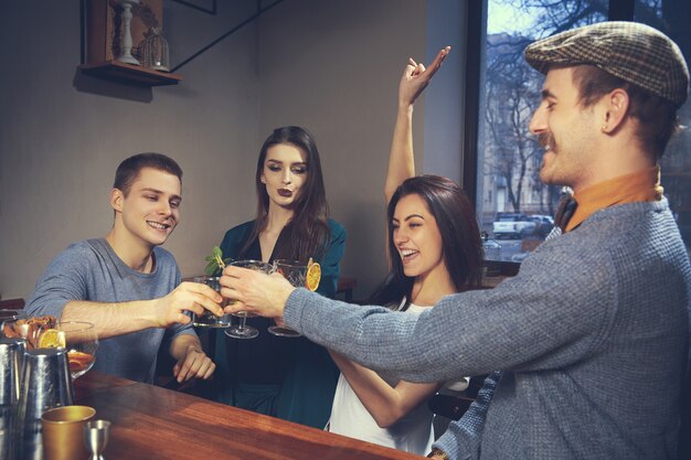 Foto de amigos alegres en el bar o en el pub comunicándose entre ellos