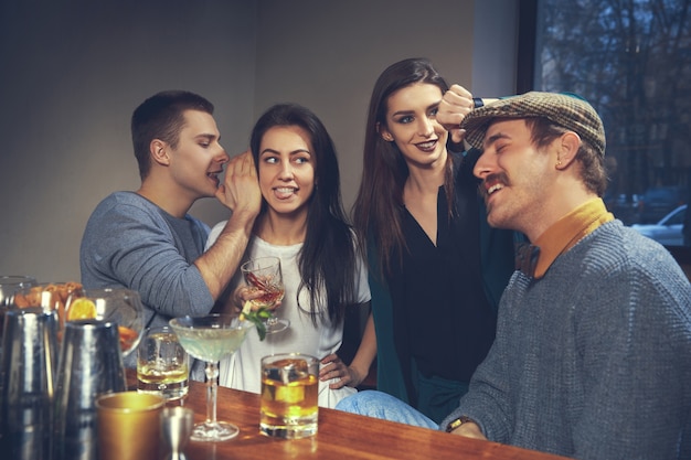 Foto de amigos alegres en el bar o en el pub comunicándose entre ellos