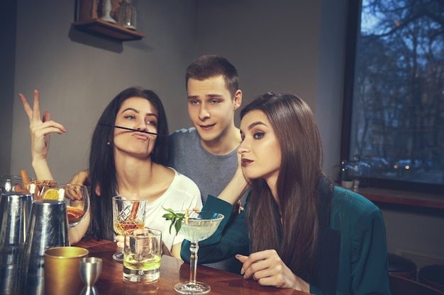 Foto de amigos alegres en el bar o en el pub comunicándose entre ellos