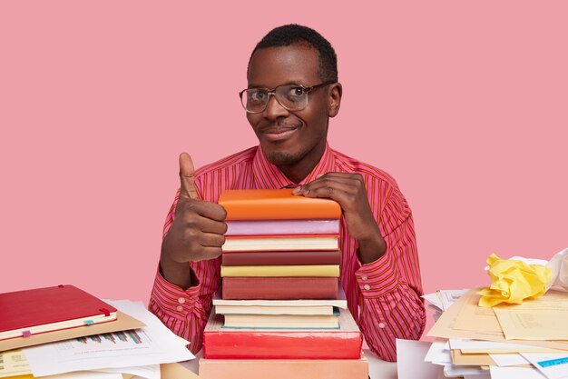 Foto de apuesto hombre afroamericano hace un buen gesto, muestra aprobación, tiene una sonrisa suave