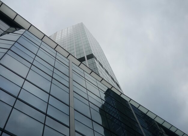 Foto arquitectónica minimalista del edificio de acero y vidrio en tiempo nublado