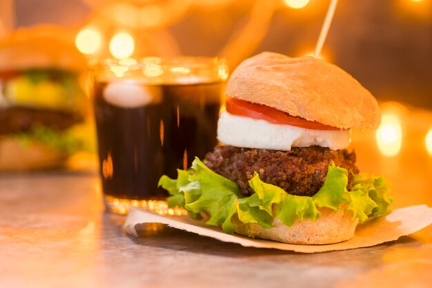 Foto artística de hamburguesa y refresco con bokeh