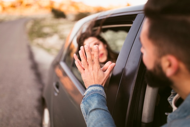 Foto gratuita foto artística hombre y mujer de la mano fuera del coche