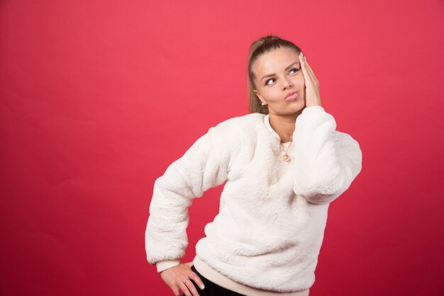 Foto de una atractiva mujer vestida con ropa casual sosteniendo la cabeza