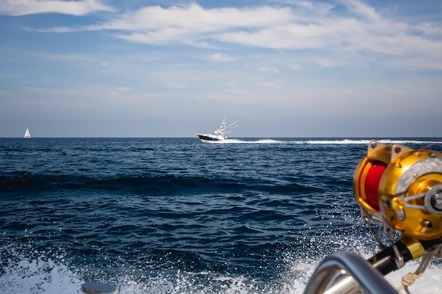 Foto de barcos de pesca navegando sobre las olas del mar bajo el cielo azul