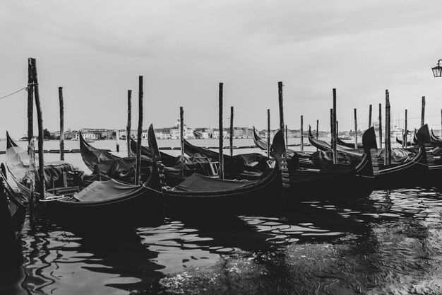 Foto en blanco y negro de góndolas atracadas en el agua