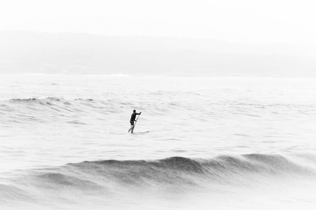 Foto en blanco y negro de una persona en medio del mar