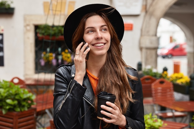 Foto de cabeza de una encantadora mujer alegre feliz de escuchar a un viejo amigo a través del teléfono celular, tiene un viaje al extranjero