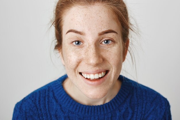 Foto de cabeza de niña pelirroja linda sonriente feliz con pecas