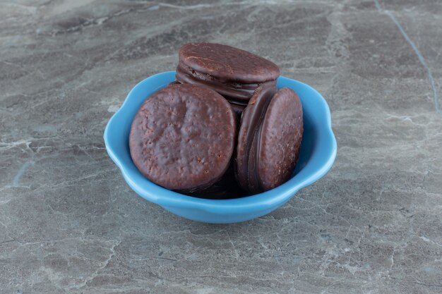 Foto de cerca de galletas de chocolate caseras frescas en un tazón azul.