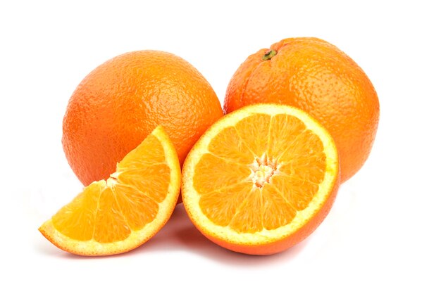 Foto de cerca de naranjas enteras o en rodajas aisladas sobre superficie blanca.