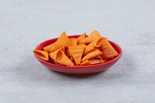 Foto de cerca de patatas fritas picantes en un tazón rojo.