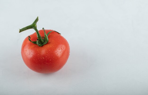 Foto de cerca de tomate maduro rojo sobre fondo blanco.