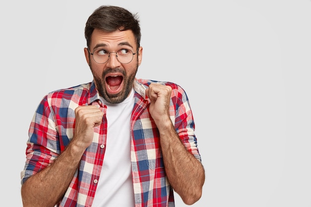 La foto de un chico emocional asombrado tiene la boca abierta, mira con expresión curiosa a un lado