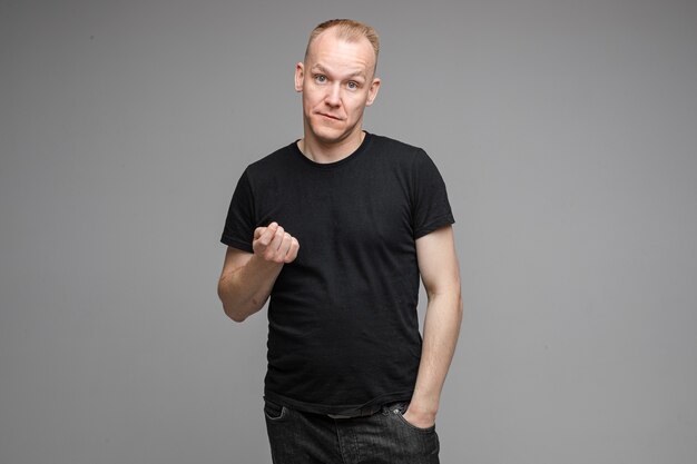 Foto de cintura para arriba del hombre adulto con camisa negra haciendo un gesto de balizamiento con la mano