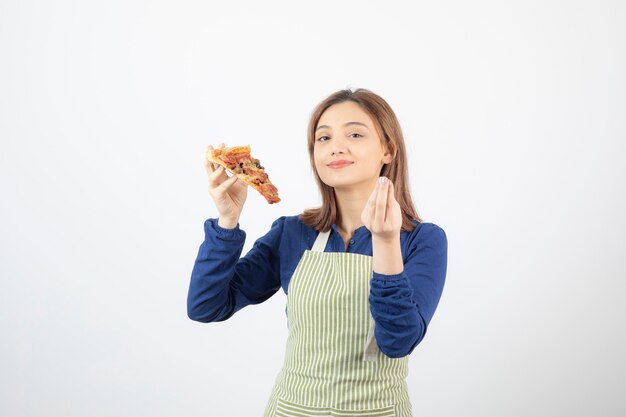 Foto de cocinera en delantal sosteniendo pizza en blanco