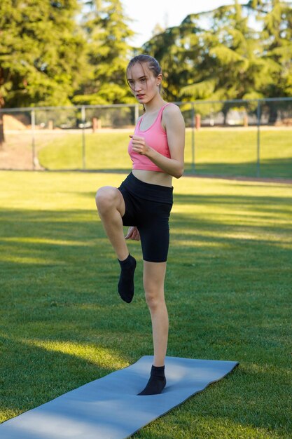 Foto de cuerpo entero de una joven haciendo su deporte matutino en el parque