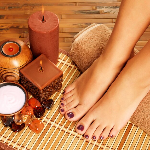 Foto de detalle de pies femeninos en el salón de spa en procedimiento de pedicura.