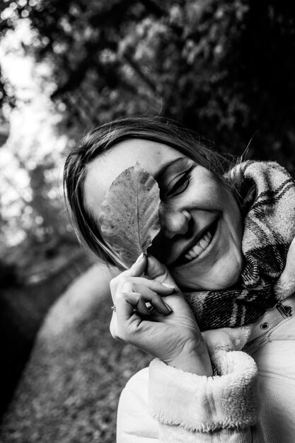 Foto en escala de grises de mujer sosteniendo hoja