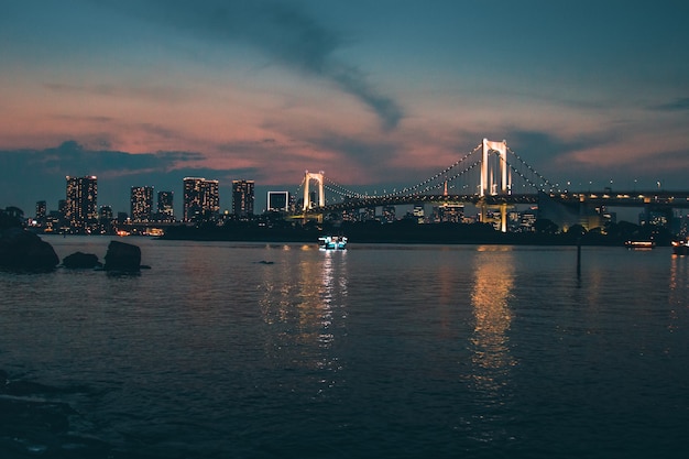 Foto escénica de la ciudad durante el amanecer con vistas al Rainbow Bridge, la ciudad de Minato, Japón