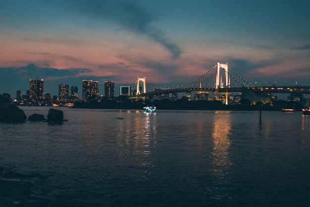 Foto escénica de la ciudad durante el amanecer con vistas al Rainbow Bridge, la ciudad de Minato, Japón