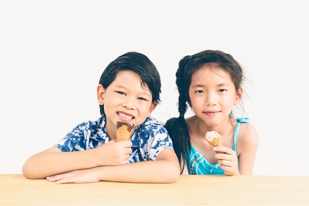 Foto de estilo vintage de niños asiáticos comiendo helado.