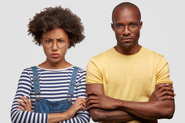 Foto de una estudiante afroamericana malhumorada disgustada y su compañero masculino