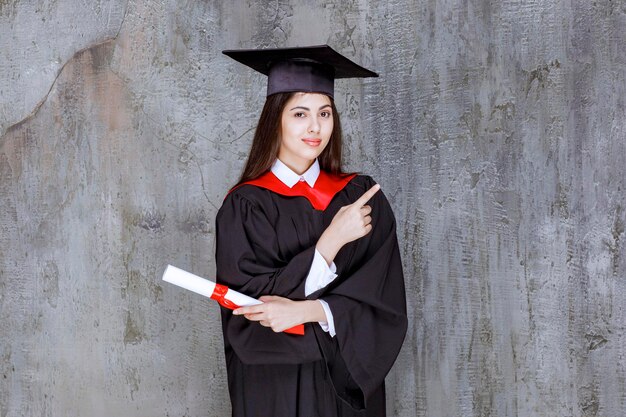 Foto de una estudiante con bata apuntando a algún lugar. foto de alta calidad