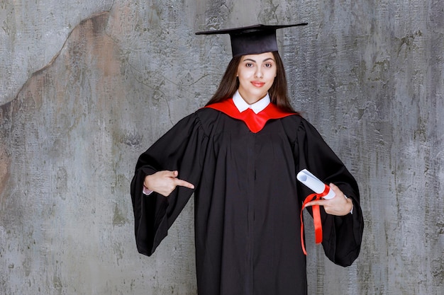 Foto gratuita foto de una estudiante con bata apuntando a algún lugar. foto de alta calidad