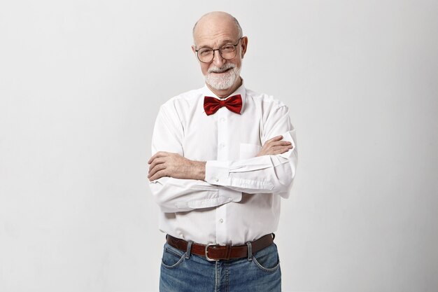 Foto de estudio de abuelo guapo alegre con barba y calva sonriendo