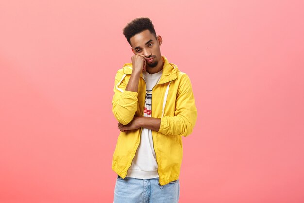 Foto de estudio de aburrido indiferente apuesto joven de piel oscura con barba y peinado afro le ...