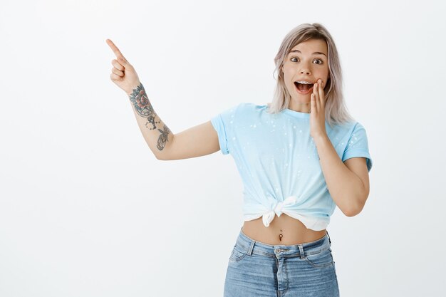 Foto de estudio de asombrada chica rubia posando en el estudio