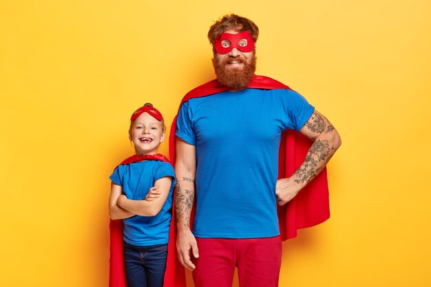 Foto de estudio de familia alegre en trajes de superhéroe