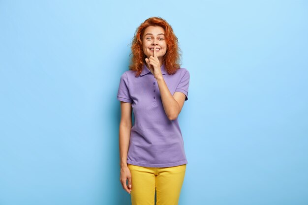 Foto de estudio de mujer hermosa pelirroja tiene sonrisa agradable