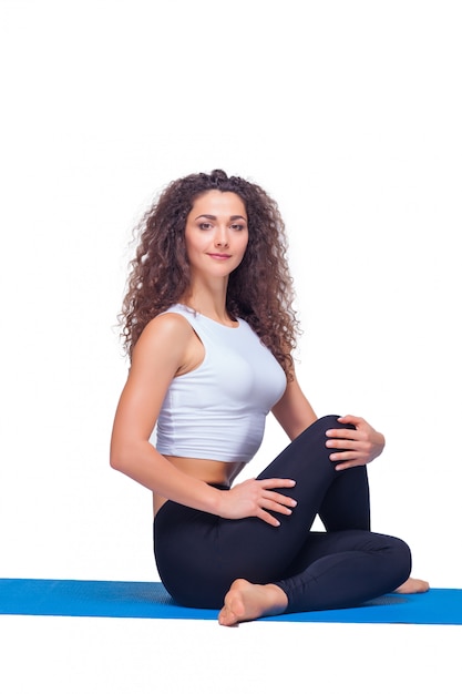 Foto de estudio de una mujer joven en forma haciendo ejercicios de yoga.