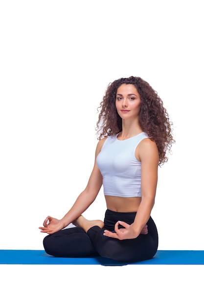 Foto de estudio de una mujer joven en forma haciendo ejercicios de yoga.