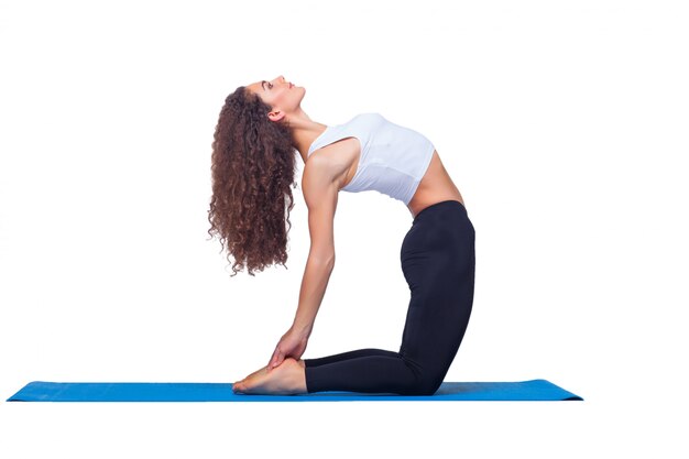 Foto de estudio de una mujer joven en forma haciendo ejercicios de yoga.