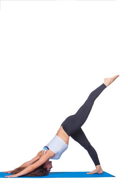 Foto de estudio de una mujer joven en forma haciendo ejercicios de yoga.