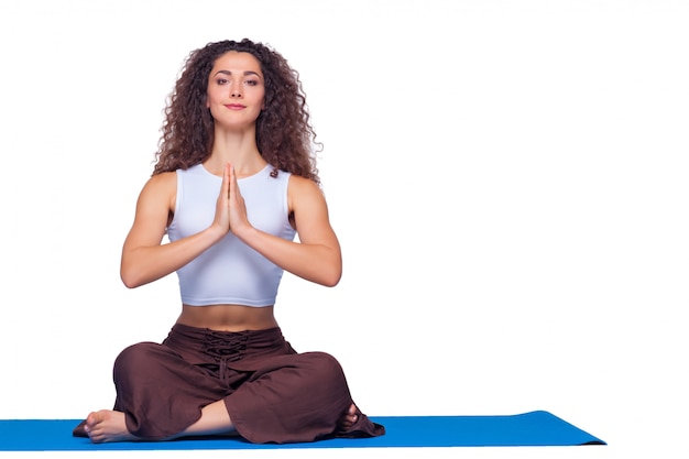 Foto de estudio de una mujer joven haciendo ejercicios de yoga