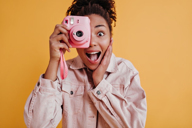 Foto de estudio de mujer sorprendida sosteniendo frente